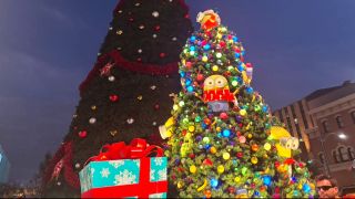 The Minions glow behind the big Christmas Tree at Universal Studios Florida during the parade.