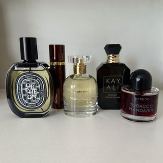 A group of some of the tobacco perfumes featured in this guide from (left to right) Diptyque, Tom Ford, & Other Stories, Kayali and Byredo