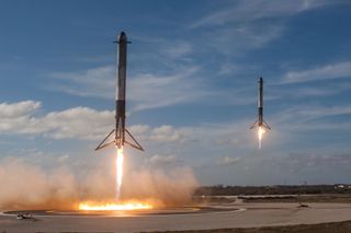 The two side boosters of SpaceX's first Falcon Heavy rocket come down for a touchdown at Cape Canaveral Air Force Station in Florida after a successful test launch on Feb. 6, 2018.