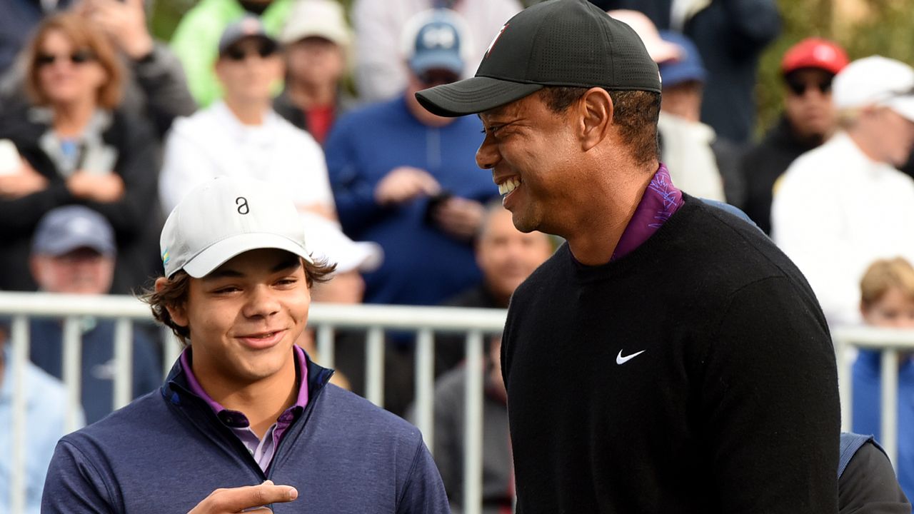 Tiger Woods and his son, Charlie Woods, share a laugh before teeing off on the first hole of the Pro-Am at the PNC Championship golf tournament at the Ritz-Carlton Golf Club.