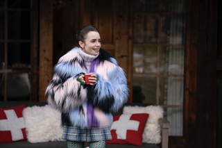 Lily Collins wears a furry jacket and a plaid skirt.