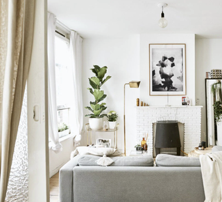 A sliding glass door, white fireplace and white walls in a small living room