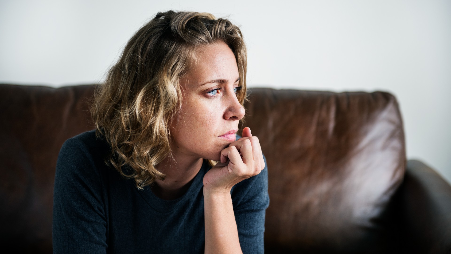Depressed woman sitting on couch