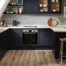 Navy kitchen with white worktops and built-in oven