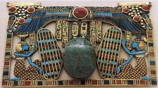 This colorful breastplate was discovered in the tomb of Tutankhamun and appears to have a scarab-shaped amulet at center. These amulets were often found in ancient Egypt, as the scarab beetle was seen as a symbol of resurrection or rebirth.