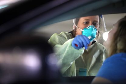 A person is tested for coronavirus in their car.
