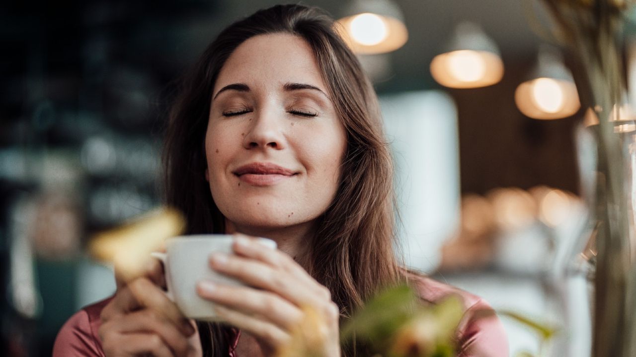 Smiling businesswoman smelling coffee in cafe, Nespresso Creatista