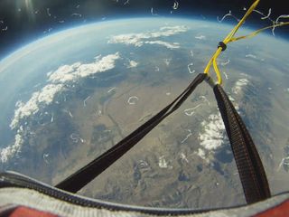 A balloon launched by students in Bishop, California, captured this photo of the Earth's surface as the balloon burst. The straps and yellow cord were holding the balloon to the payload container. The white strips floating in the foreground are pieces of