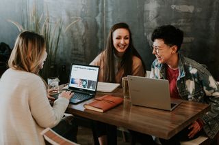 Three people with Chromebooks laughing