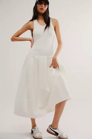 a model wears a white sleeveless midi dress