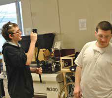 An MC2STEM tenth grader films an interview with a fellow student using a GoPro. 