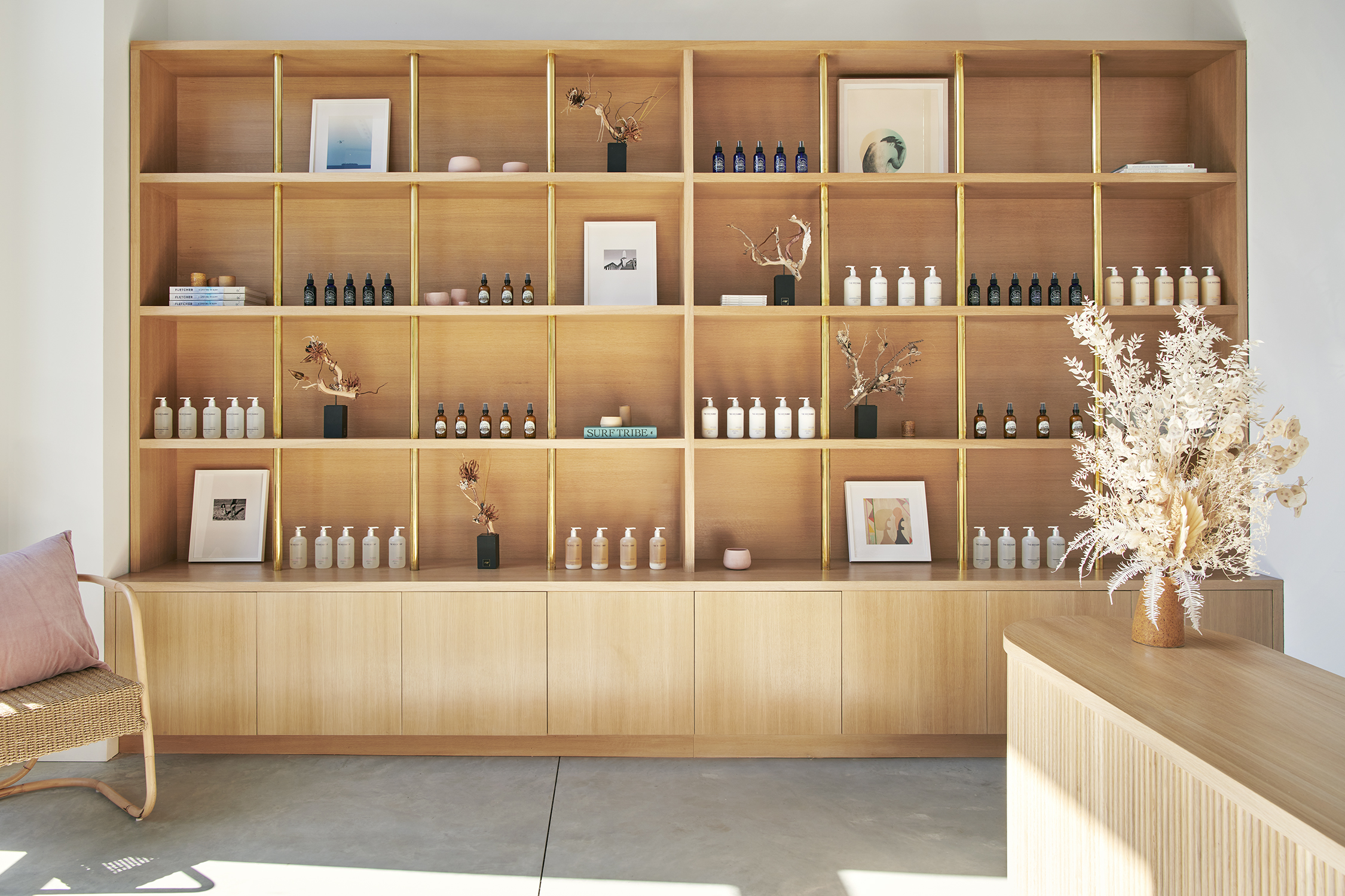 A wood-clad hotel boutique features a shelf filled with pastel-shaded items.