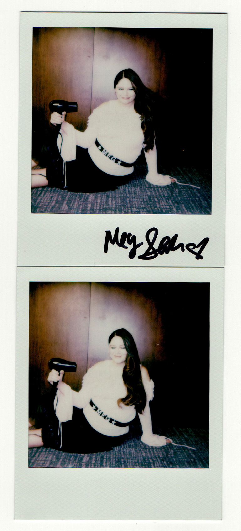 polaroids of actress meg stalter sitting on the ground blow drying her hair wearing an off the shoulder sweater a black skirt and a belt that says meg