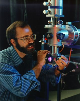 Scott Sandford of NASA’s Ames Research Center looks into the sample chamber of one of the cryovacuum systems to study the chemical processes that can happen in space.