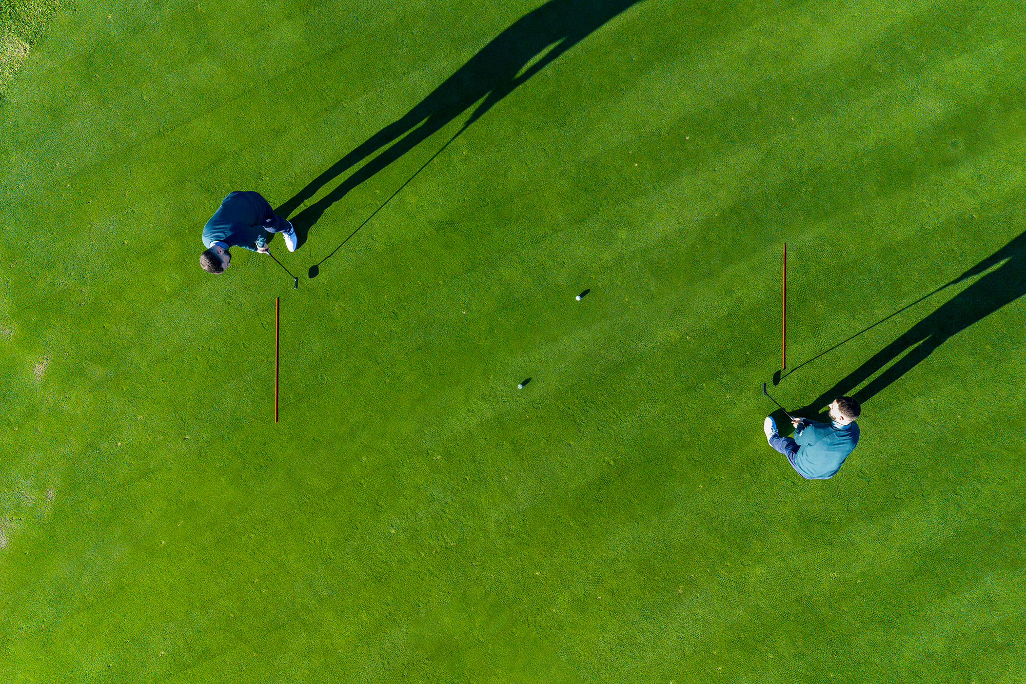 Putting Specialist Coach James Jankowksi demonstrating a drill using alignment sticks to help with putting speed, from an aerial view