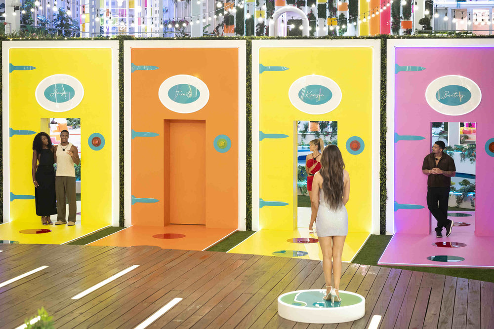 The Day 1 Islanders (Aniya Harvey, KC Chandler, Kenzie Annis, and Sean Reifel) stand in front of multi-colored doors while choosing their couples, in 'Love Island USA' season 8.