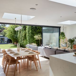 Open-plan room in extension with dining table, corner sofa and kitchen island