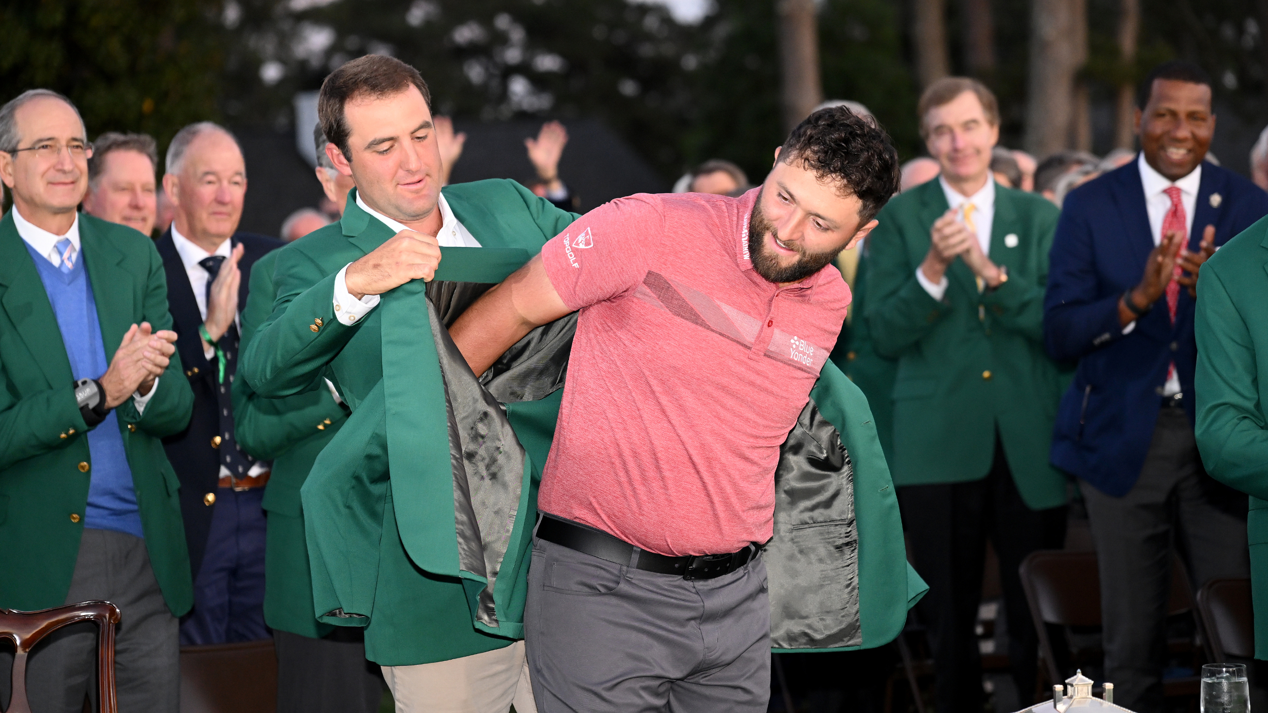 Scottie Scheffler hands Jon Rahm the Green Jacket after the 2023 Masters