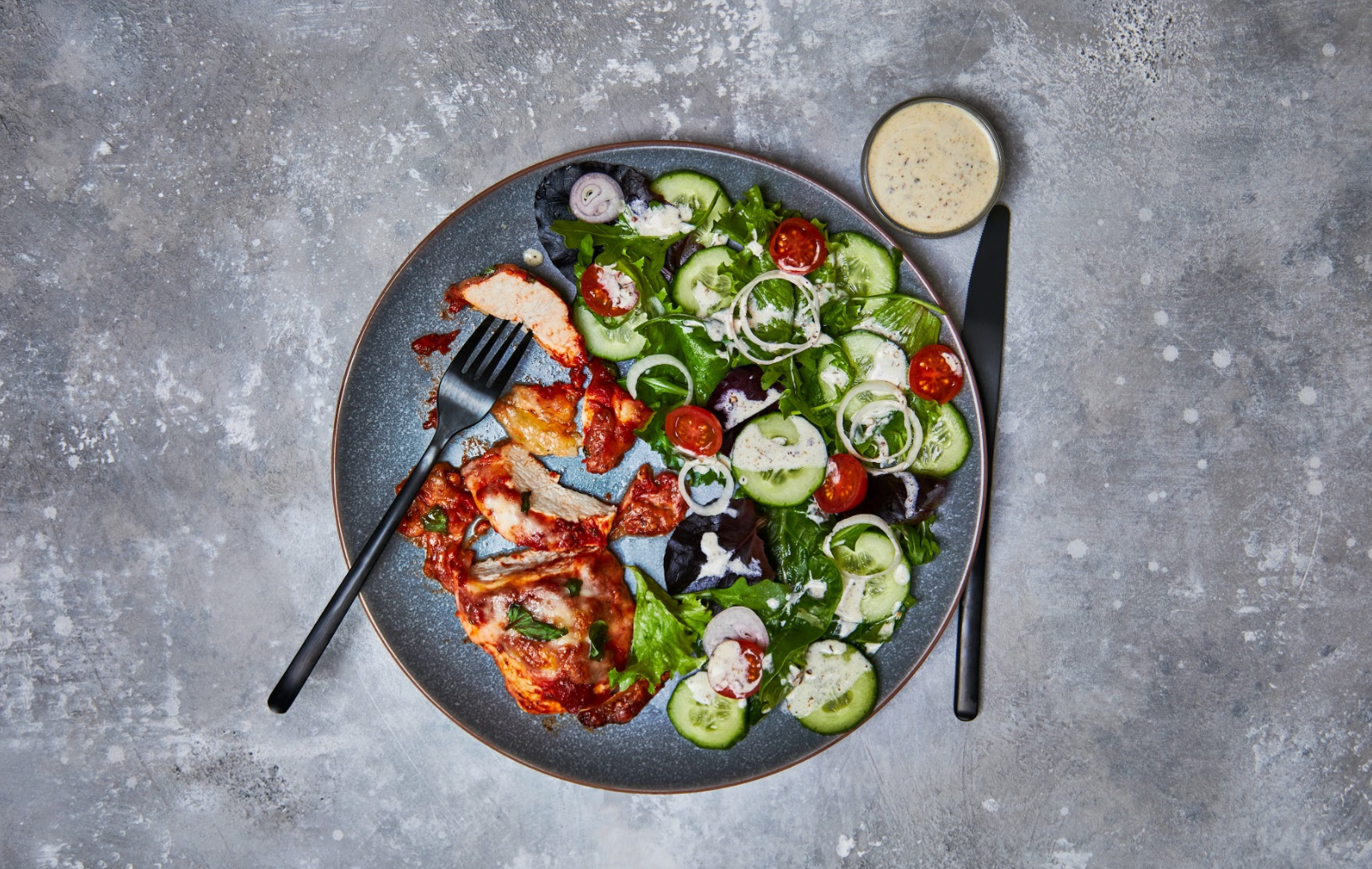 Joe Wicks' cheesy pizza-topped chicken with mixed salad recipe