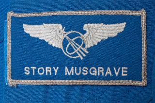 name patch on a blue astronaut flight suit that reads "story musgrave"