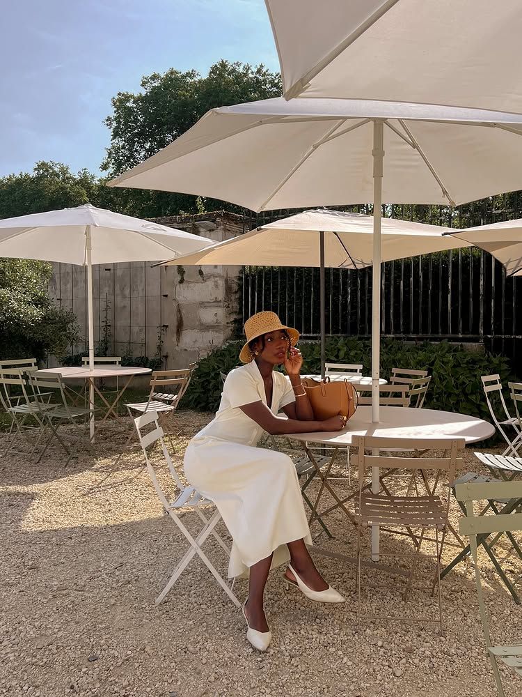 @aidabadji_ wears a cream dress, straw hat and cream slingback heels