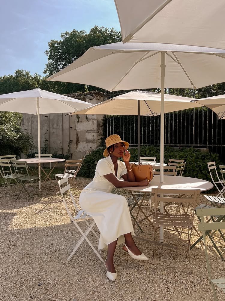 @aidabadji_ wears a cream dress, straw hat and cream slingback heels