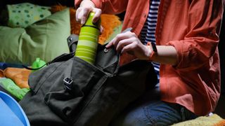 person packing big rucksack for hiking