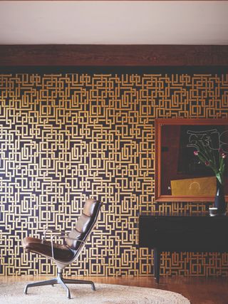 Seventies printed wallpaper in home office with black leather chair