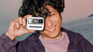 Young person using a Polaroid Now Gen 3 outdoors