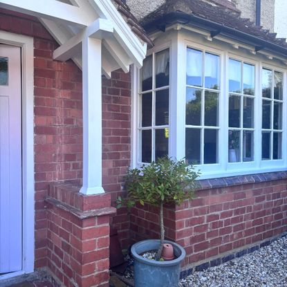 front of a brick house with bay window and white painted porch