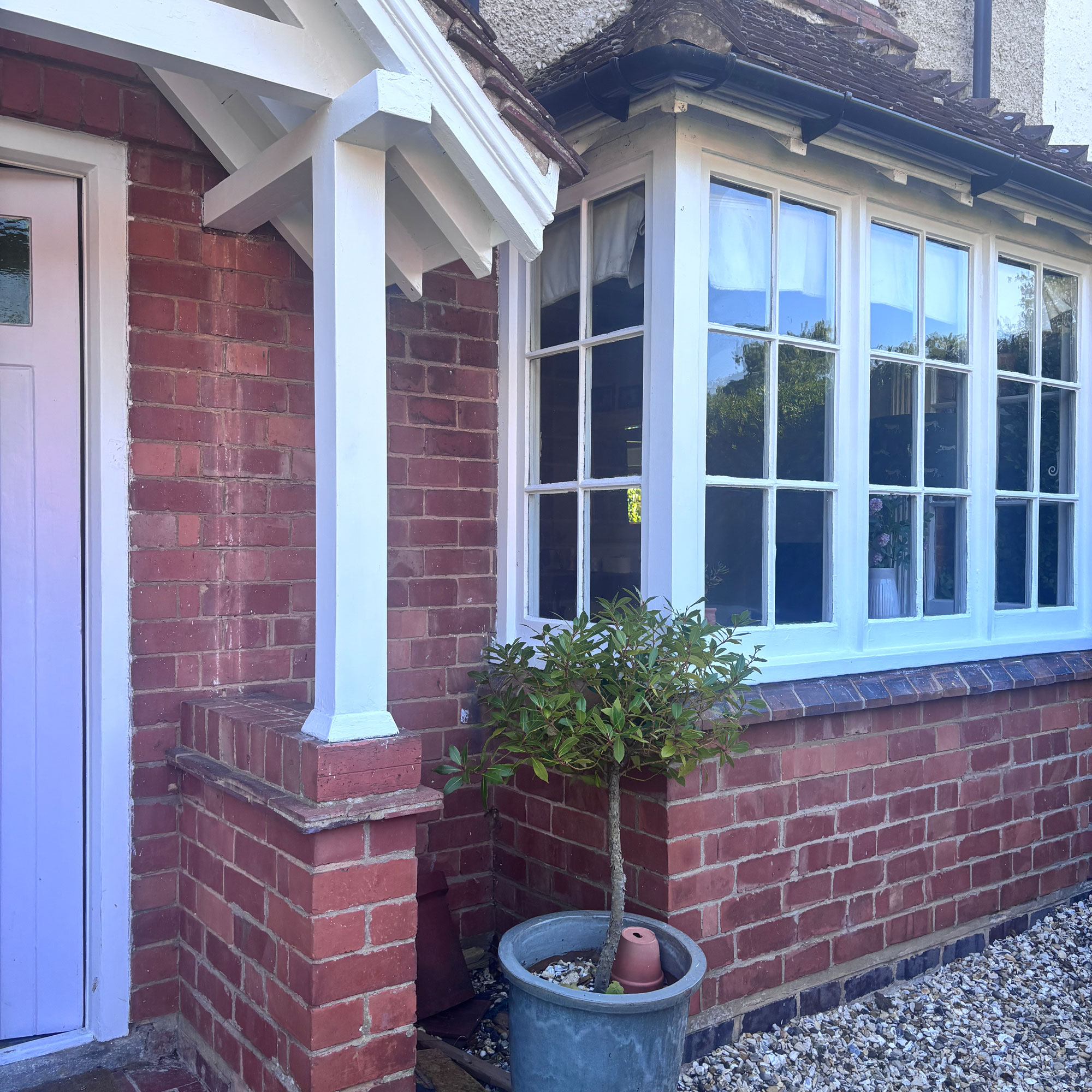 front of a brick house with bay window and white painted porch