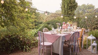 outdoor table with LED candles and festoon lights overhead