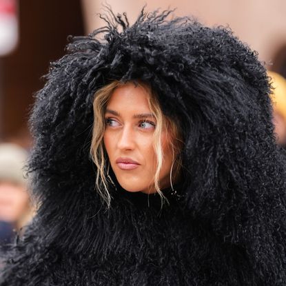 a woman during fashion week wearing a black shearling hood - best gentle cleansers