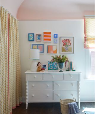 kids bedroom with white walls, pink ceiling, white dresser and gallery wall with colorful artwork