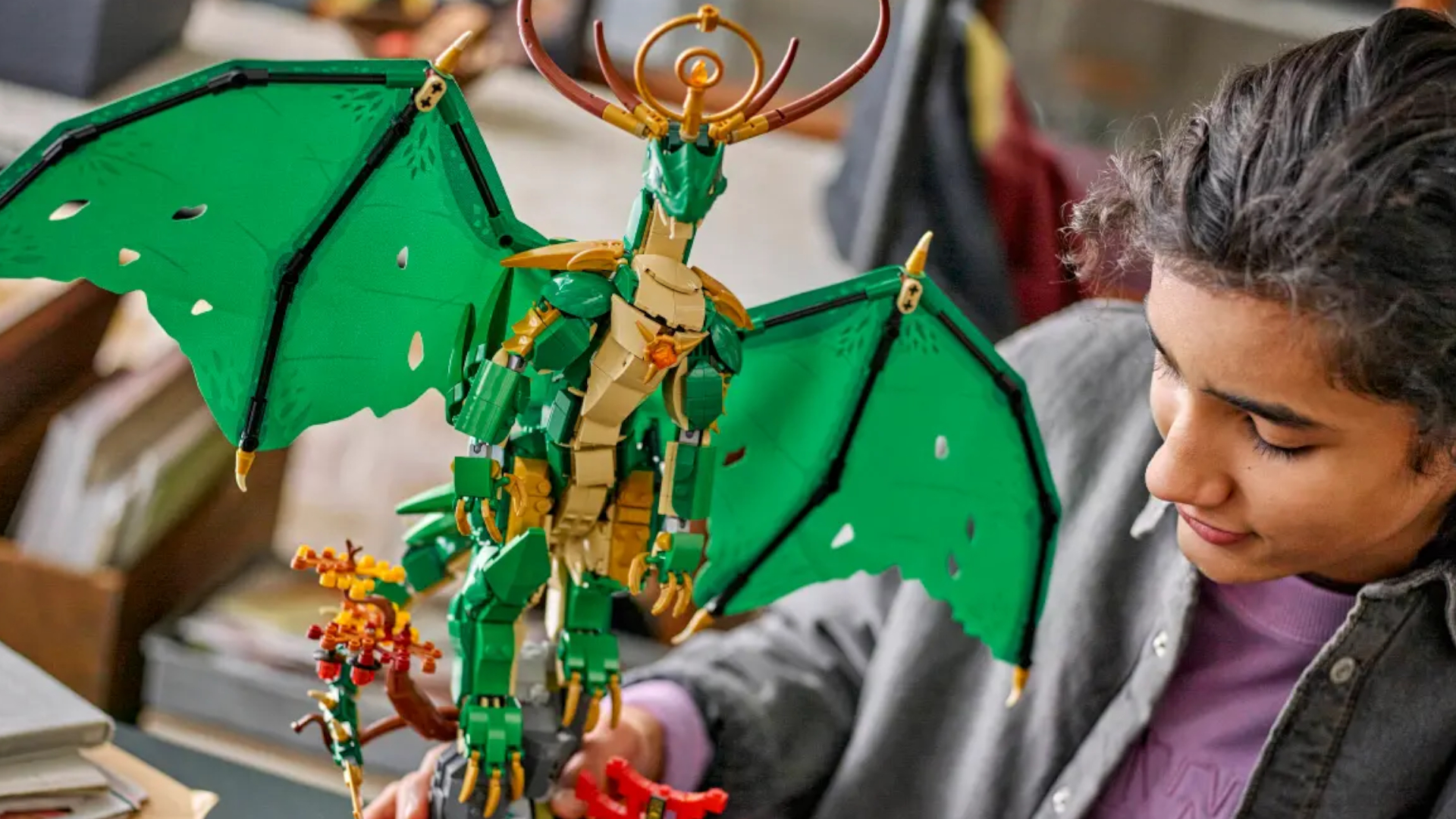 A girl constructs the Lego The Guardian Dragon set
