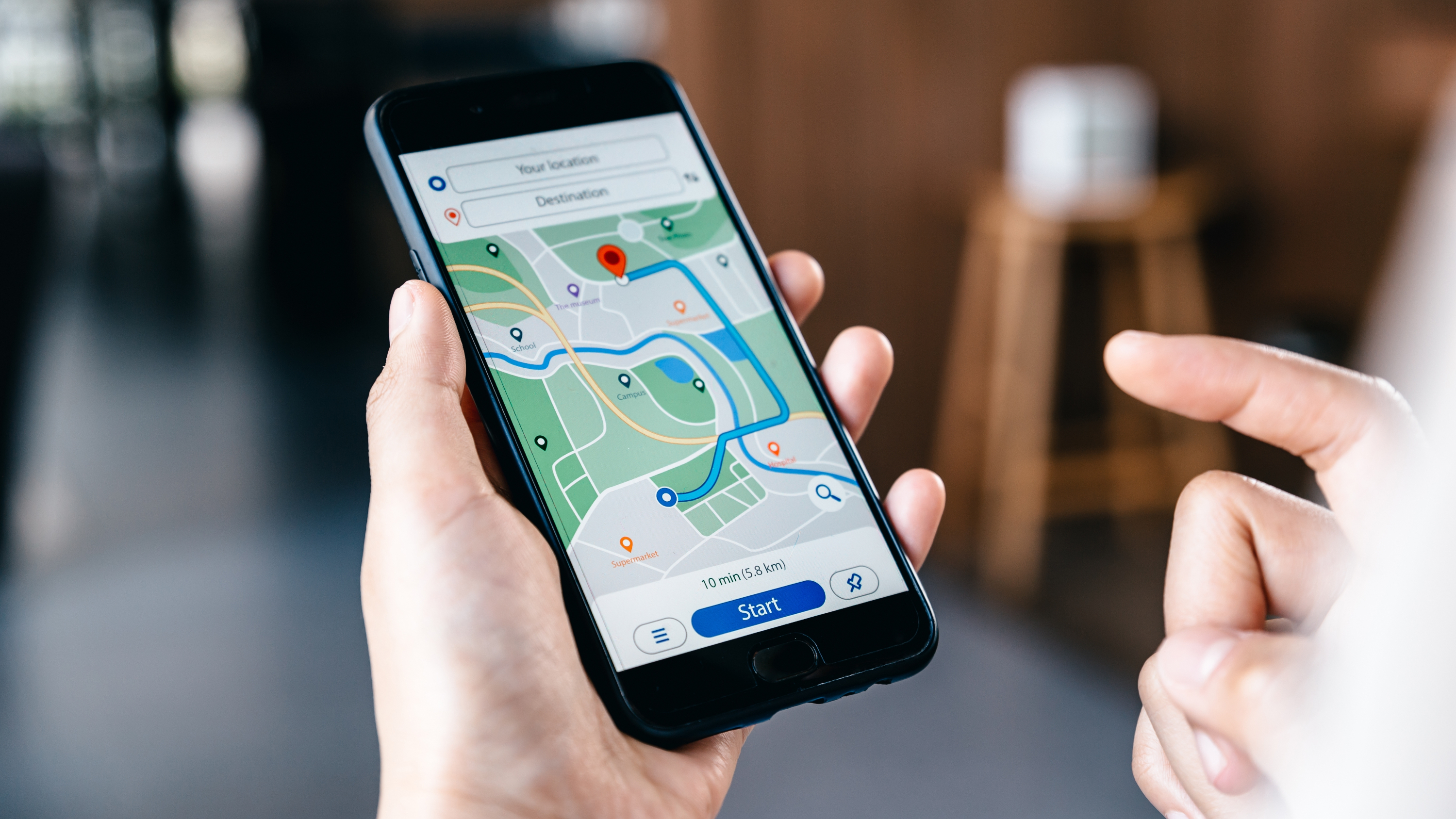 Hand searching location in map online on smartphone