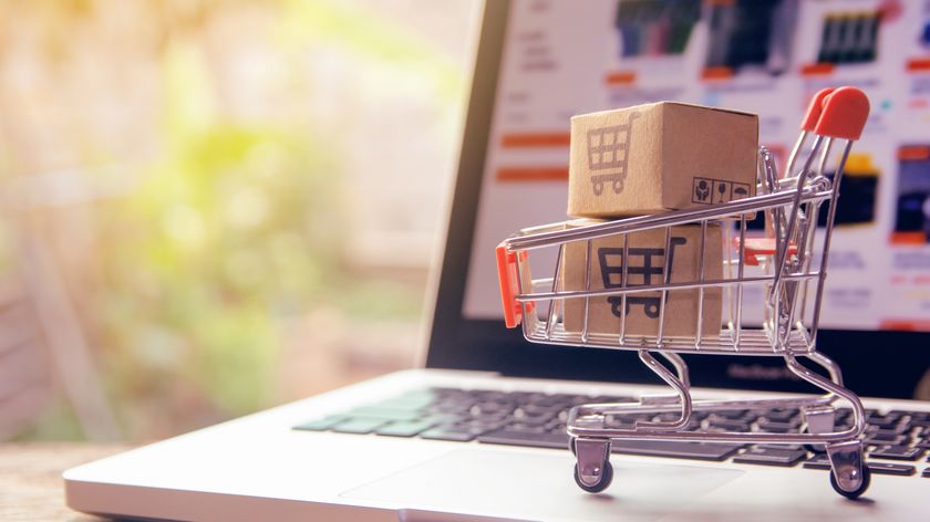 Parcels stamped with a shopping cart logo in a trolley on a laptop keyboard