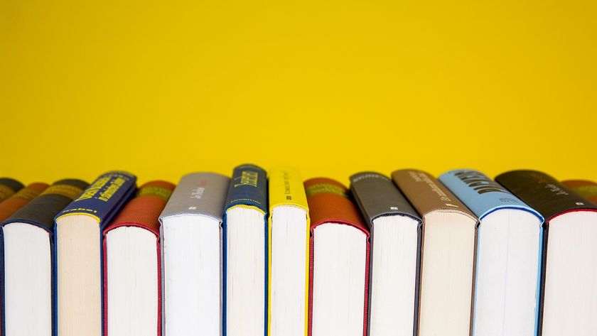 A series of books stacked horizontally so we only see the bottom of their pages with a bright yellow background behind.