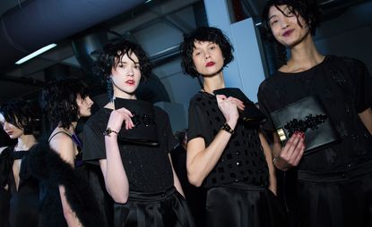Models all black outfits, satin pants with sequence embroidered t-shirts, and black leather handbags, from Emporio Armani A/W 2015 collection.