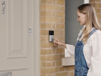 A woman ringing a video doorbell at a front door