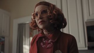 Amy Madigan with a red wig, in a red outfit and big red sunglasses in Weapons