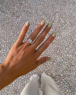 Woman wearing east-west emerald-cut bezel engagement rings.