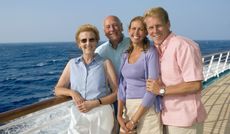 Two couples standing on the deck of a cruise ship.