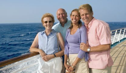 Two couples standing on the deck of a cruise ship.
