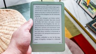 A hand holding the Amazon Kindle 2024 with a page of a book displayed on it