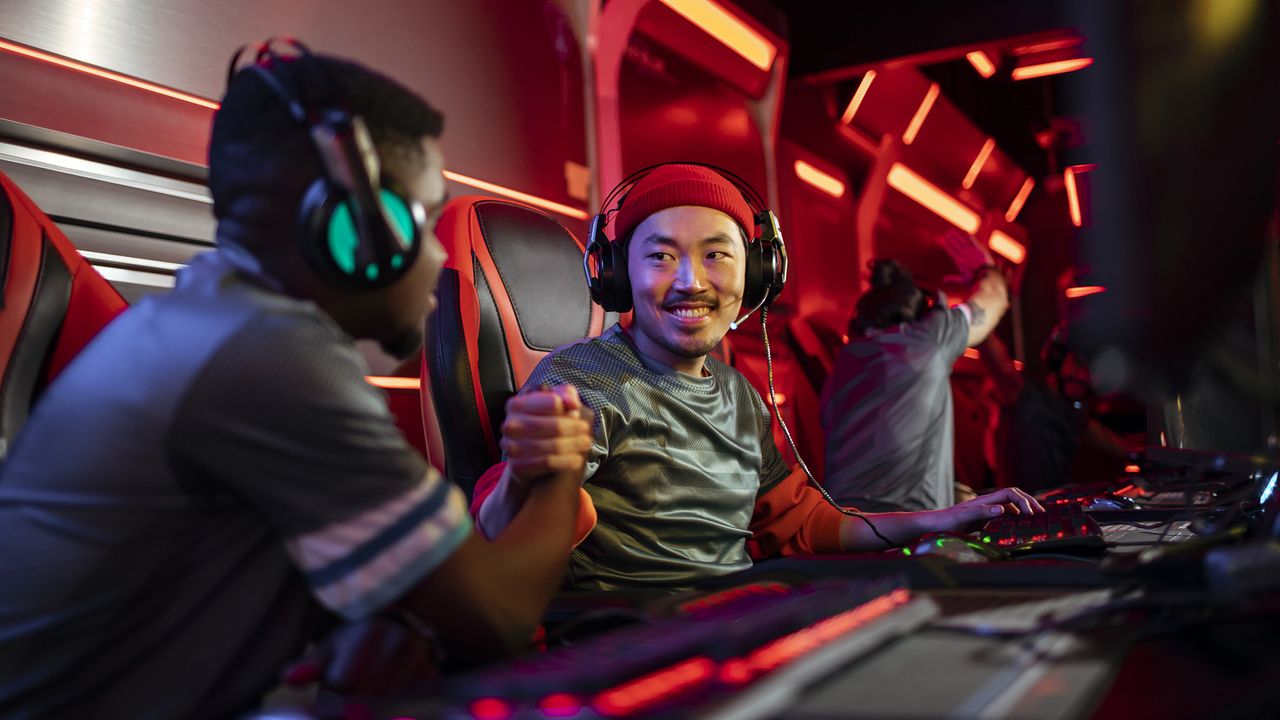 eSports gamers wearing gaming headsets and fist-bumping