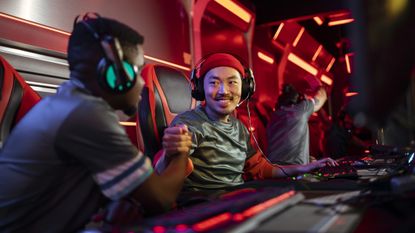 eSports gamers wearing gaming headsets and fist-bumping
