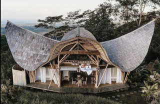 house in the mountains with wing shaped roof