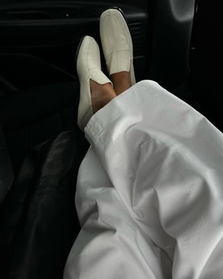 Influencer wears white loafers.