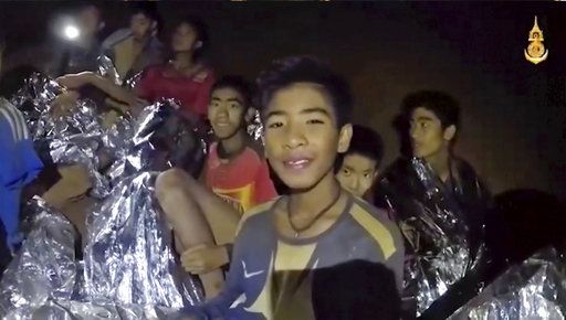 Thai boys smile as Thai Navy SEAL medic help injured children inside a cave in Mae Sai, northern Thailand.